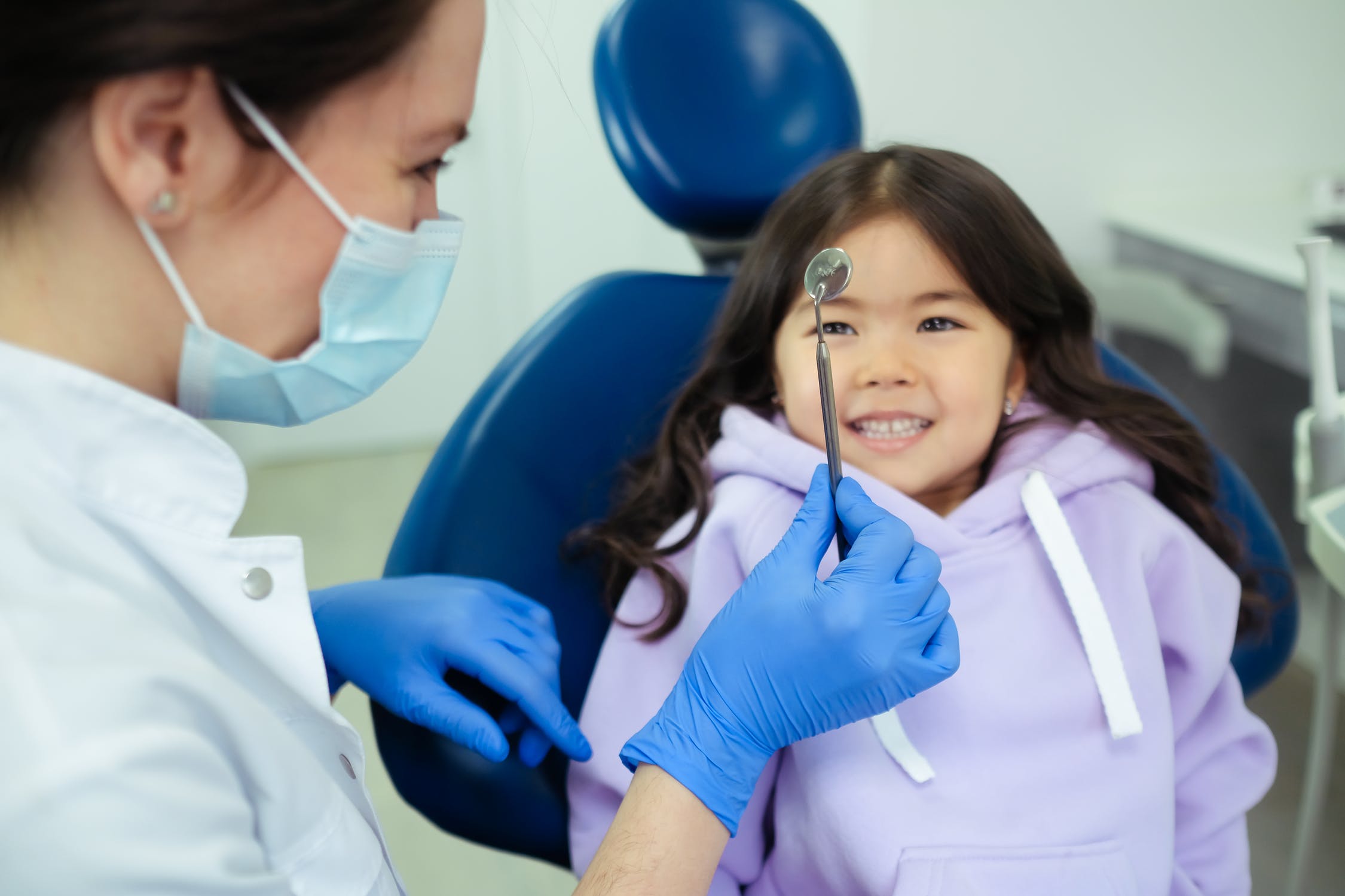 a woman holding a stethoscope around a child's neck