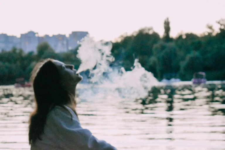 a person looking at a body of water with trees in the background